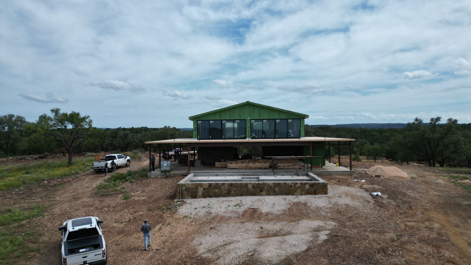 Two-story steel barndominium under construction on a Texas Hill Country hilltop, built by Elevation Development