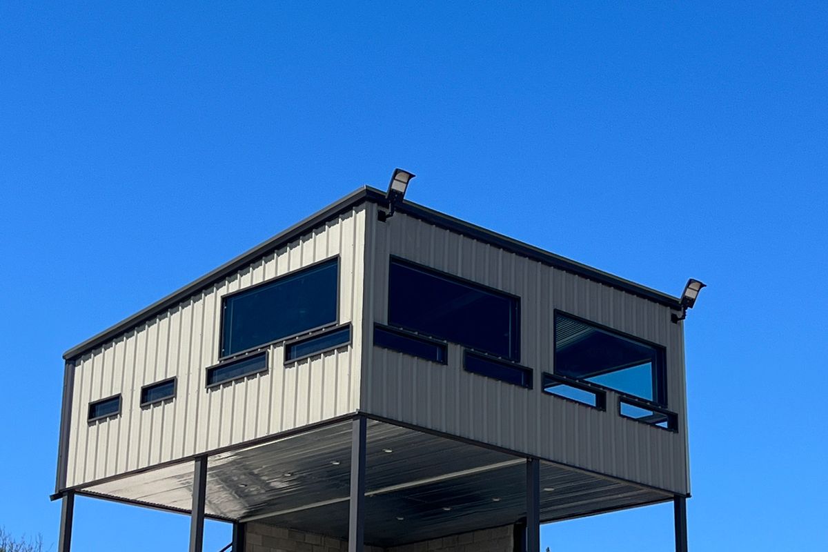 Elevated steel shooting tower overlooking a Hill Country ranch